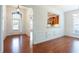 Inviting entryway with hardwood floors, white wainscoting, and a view into an adjacent room at 4520 Vanadium Bnd, Cumming, GA 30040