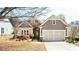 Charming single-story home with stone accents, a well-manicured lawn, and a two-car garage at 4520 Vanadium Bnd, Cumming, GA 30040