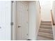 Hallway with carpeted stairs, white doors, and neutral walls provide a simple, clean aesthetic at 4520 Vanadium Bnd, Cumming, GA 30040