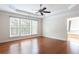 Spacious main bedroom with tray ceiling, hardwood floors, and natural light from multiple windows at 4520 Vanadium Bnd, Cumming, GA 30040