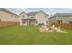 Large backyard with a green lawn, a brick fire pit area with seating and covered patio at 5085 Mundy Dr, Cumming, GA 30028