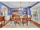 Elegant dining room with blue walls, hardwood floors, and classic furnishings, adjacent to the kitchen at 5085 Mundy Dr, Cumming, GA 30028