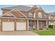 Lovely brick home featuring a spacious two-car garage, covered porch, and well-maintained front lawn at 5085 Mundy Dr, Cumming, GA 30028