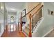 Inviting foyer with gleaming hardwood floors, a staircase, and a glimpse of the front door and living spaces at 5085 Mundy Dr, Cumming, GA 30028