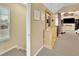 Light-filled hallway leads to bedroom with dresser and television in the distance at 5085 Mundy Dr, Cumming, GA 30028