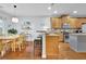 Open kitchen with light wood cabinets, stainless steel appliances, a granite-topped island, and a breakfast table at 5085 Mundy Dr, Cumming, GA 30028