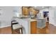 Spacious kitchen featuring a breakfast bar, stainless steel appliances, and a seamless transition to the dining area at 5085 Mundy Dr, Cumming, GA 30028