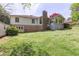 Backyard view of house featuring lush lawn, brick accents, and sunroom at 660 Hembree Rd, Roswell, GA 30076
