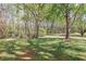 View of the home's grassy backyard and mature trees, perfect for outdoor activities at 660 Hembree Rd, Roswell, GA 30076