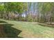 Sprawling backyard featuring lush green grass and mature trees at 660 Hembree Rd, Roswell, GA 30076