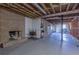 View of unfinished basement with brick fireplace, storage shelving, and exposed ducts at 660 Hembree Rd, Roswell, GA 30076