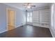 This bedroom includes a ceiling fan, dark wooden floors, and a large white shelving unit at 660 Hembree Rd, Roswell, GA 30076