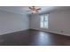 This bedroom features dark wood floors, a ceiling fan, one window and neutral colored walls at 660 Hembree Rd, Roswell, GA 30076