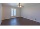 This bedroom features dark wood floors, a ceiling fan, one window and neutral colored walls at 660 Hembree Rd, Roswell, GA 30076