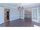 Dining area featuring hardwood floors, stylish chandelier, and open doorway to a kitchen at 660 Hembree Rd, Roswell, GA 30076