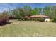 Single-story home with mature trees and landscaping at 660 Hembree Rd, Roswell, GA 30076
