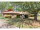 Single-story home with stone facade, mature trees, and a well-manicured lawn at 660 Hembree Rd, Roswell, GA 30076