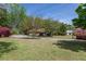 Well-manicured front yard with mature trees and ample parking space on the driveway at 660 Hembree Rd, Roswell, GA 30076