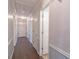 Hallway with wood flooring, white trim, and access to multiple rooms at 660 Hembree Rd, Roswell, GA 30076
