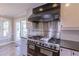 Close up of stainless range and hood in the kitchen with view to breakfast nook at 660 Hembree Rd, Roswell, GA 30076