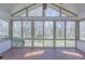 Sunroom featuring paneled ceiling, large windows, and tiled flooring with views of the backyard at 660 Hembree Rd, Roswell, GA 30076
