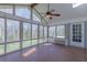 Bright sunroom with tiled flooring, ceiling fan, and large windows overlooking the backyard at 660 Hembree Rd, Roswell, GA 30076