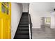 Entryway view showing black staircase and yellow front door leading into the living space at 1071 N Price Rd, Sugar Hill, GA 30518
