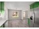 Eat-in kitchen with stainless steel refrigerator, white countertop and vibrant green cabinets at 1071 N Price Rd, Sugar Hill, GA 30518
