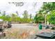 Spacious gravel backyard with landscaping equipment, storage, a fence, and a wooded area at 1486 Harbins Rd, Norcross, GA 30093