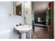 Bathroom with white pedestal sink, classic mirror, and view into bedroom at 1486 Harbins Rd, Norcross, GA 30093