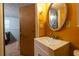 Bathroom with custom vanity, round mirror, and accent lighting at 1486 Harbins Rd, Norcross, GA 30093