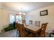 Cozy dining room featuring wood table and chairs, chandelier lighting, and a sliding door to the outside deck at 1486 Harbins Rd, Norcross, GA 30093
