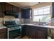 Kitchen features stainless steel appliances, dark cabinetry, and tile floors at 1486 Harbins Rd, Norcross, GA 30093