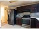 Kitchen with stainless steel appliances, dark cabinets, and tile flooring at 1486 Harbins Rd, Norcross, GA 30093