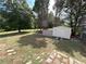 Large backyard featuring a storage shed, mature trees, a chain link fence, and a grassy lawn at 5791 Warren Farm Sw Rd, Powder Springs, GA 30127