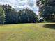 Large backyard with a shed surrounded by lush green trees at 5791 Warren Farm Sw Rd, Powder Springs, GA 30127