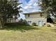 Backyard view featuring a basement entrance, storage shed, retaining wall, and spacious green lawn at 5791 Warren Farm Sw Rd, Powder Springs, GA 30127