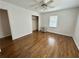 Bright bedroom featuring hardwood floors, ceiling fan, closet, and large window at 5791 Warren Farm Sw Rd, Powder Springs, GA 30127