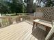 View of a wood deck with railing, bench, and a gate to the yard, surrounded by mature trees in the background at 5791 Warren Farm Sw Rd, Powder Springs, GA 30127
