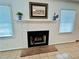 Close up of a traditional fireplace with mantle and tile flooring beneath two windows at 5791 Warren Farm Sw Rd, Powder Springs, GA 30127