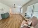 Bright living room featuring wood floors, chandelier, large windows, mint dresser and pink chair at 5791 Warren Farm Sw Rd, Powder Springs, GA 30127