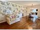 Living room featuring hardwood floors, floral wallpaper, and a view into the kitchen at 5791 Warren Farm Sw Rd, Powder Springs, GA 30127