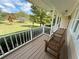 Cozy covered porch with a wooden bench overlooking the spacious, tree-filled front yard at 5791 Warren Farm Sw Rd, Powder Springs, GA 30127