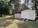 Backyard storage shed with an attached covered area, surrounded by a chain link fence and mature trees at 5791 Warren Farm Sw Rd, Powder Springs, GA 30127