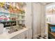 Wet bar features mirrored backsplash, glassware, shelving, and black and white tile floor at 8 W Andrews Nw Dr, Atlanta, GA 30305
