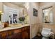 Cozy bathroom features a wood vanity, marble countertop, decorative mirror, and tiled walls at 8 W Andrews Nw Dr, Atlanta, GA 30305