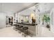 Bright kitchen featuring a large island with seating and black countertops, and white cabinetry throughout at 8 W Andrews Nw Dr, Atlanta, GA 30305