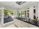Open kitchen with an island featuring black countertops, and large windows and doors to an outdoor living space at 8 W Andrews Nw Dr, Atlanta, GA 30305