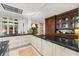 Luxury kitchen with an island featuring black countertops and custom cabinetry, and stainless steel appliances at 8 W Andrews Nw Dr, Atlanta, GA 30305