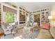 Cozy living room with built-in bookshelves, large windows with seating, and hardwood floors at 8 W Andrews Nw Dr, Atlanta, GA 30305
